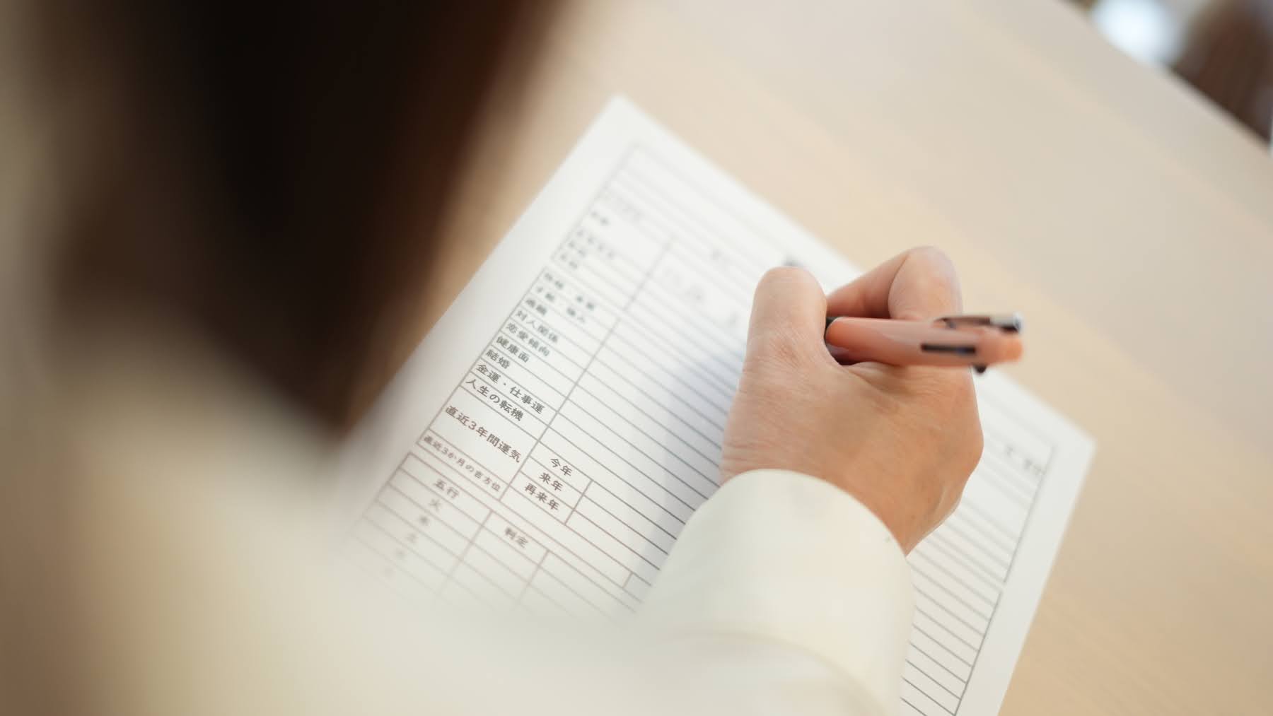 鑑定書に丁寧にお客様の本質を書き込んでいる様子